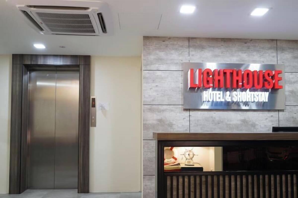 Zona de recepción de hotel con un cartel que dice 'Lighthouse Hotel & ShortStay'.