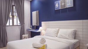Una habitación de hotel con cama, escritorio, espejo y ventana con cortinas.
