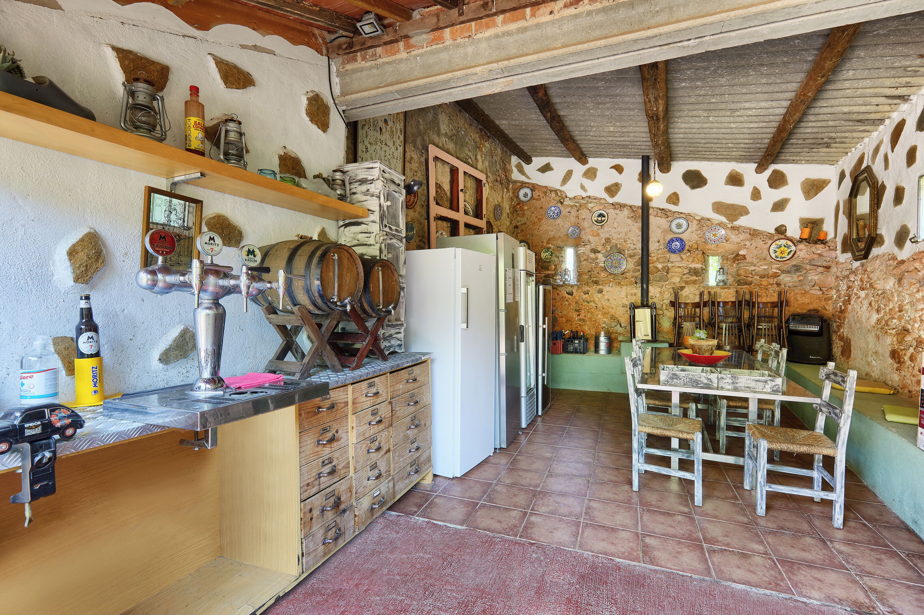 Une cuisine rustique avec un comptoir en bois, un réfrigérateur et une table à manger avec des chaises.