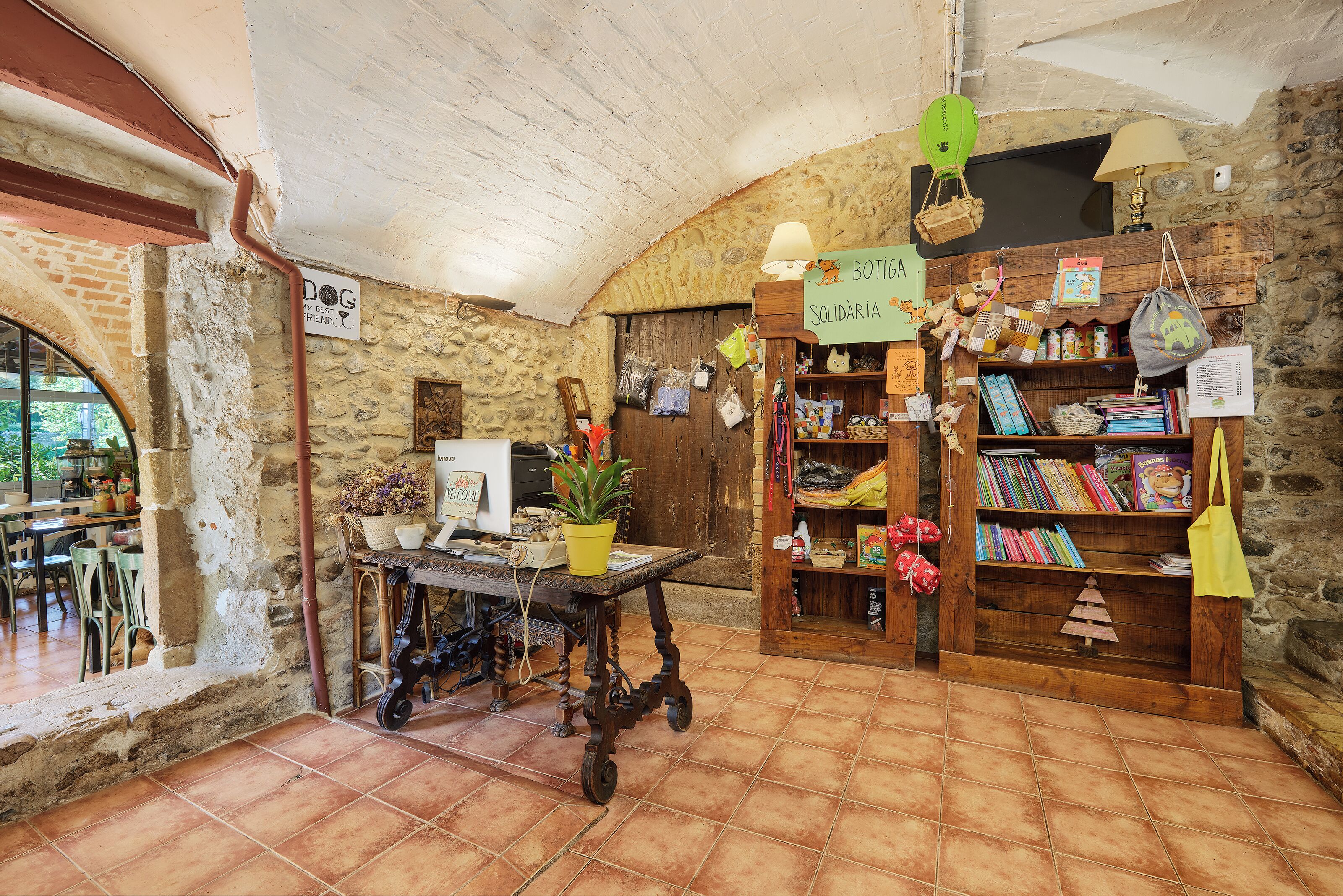 A rustic interior with a wooden bookshelf, a table with a potted plant, and a sign reading "DOG MY BEST FRIEND".