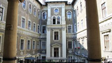 A courtyard with classical architecture, featuring columns and ornate windows.