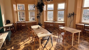 A room with large windows, a chandelier, and patterned floor tiles.