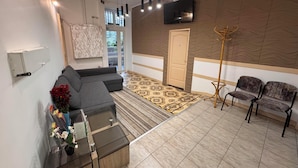 A modern living room with a sectional sofa, a glass coffee table, and a decorative vase with flowers.