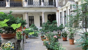 A courtyard with potted plants and a tiled floor.