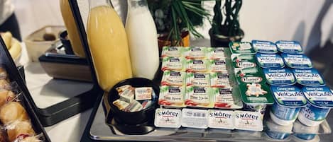 A buffet table with various food items, including pastries, dairy products, and beverages.