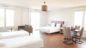 Una habitación de hotel moderna con una cama, un sofá, un escritorio y una silla.