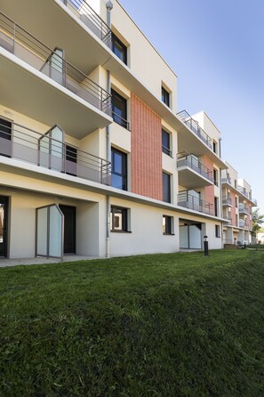 Stylish building with a clean design, featuring large windows and balconies.