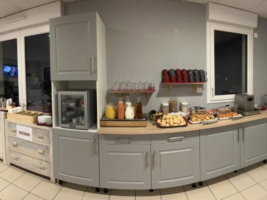 A kitchen area with a built-in microwave, coffee machine, and various food items on the counter.
