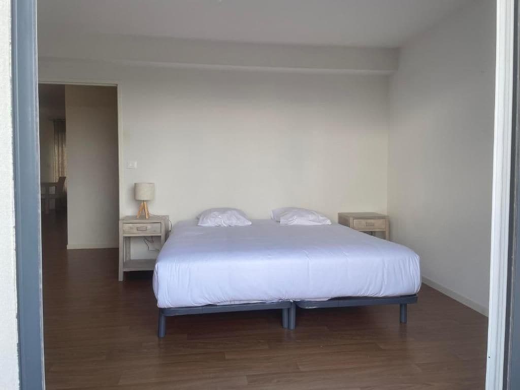 Un dormitorio con una cama individual, dos mesitas de noche y un tocador.