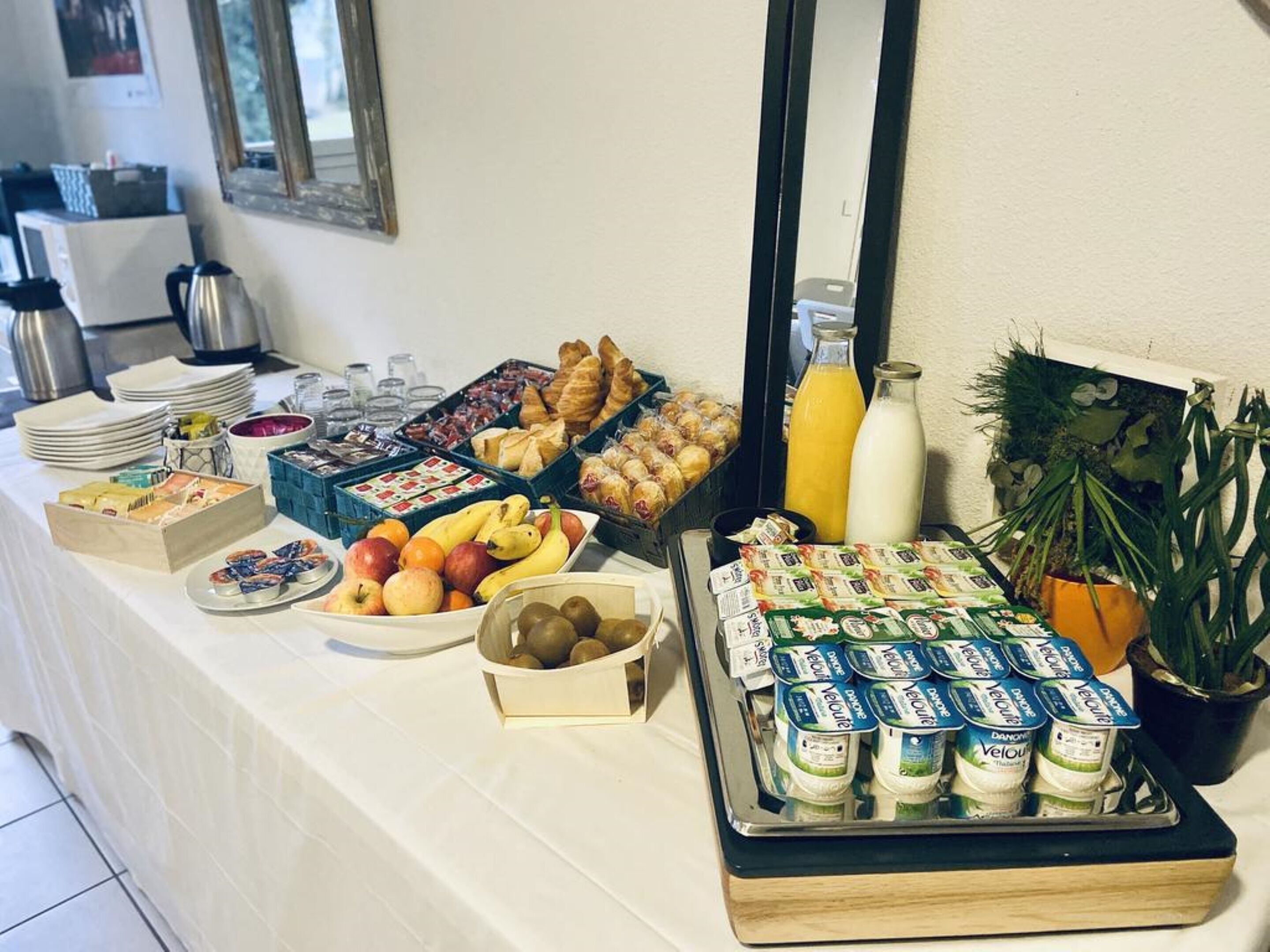 A buffet with various food items including fruits, pastries, and dairy products.