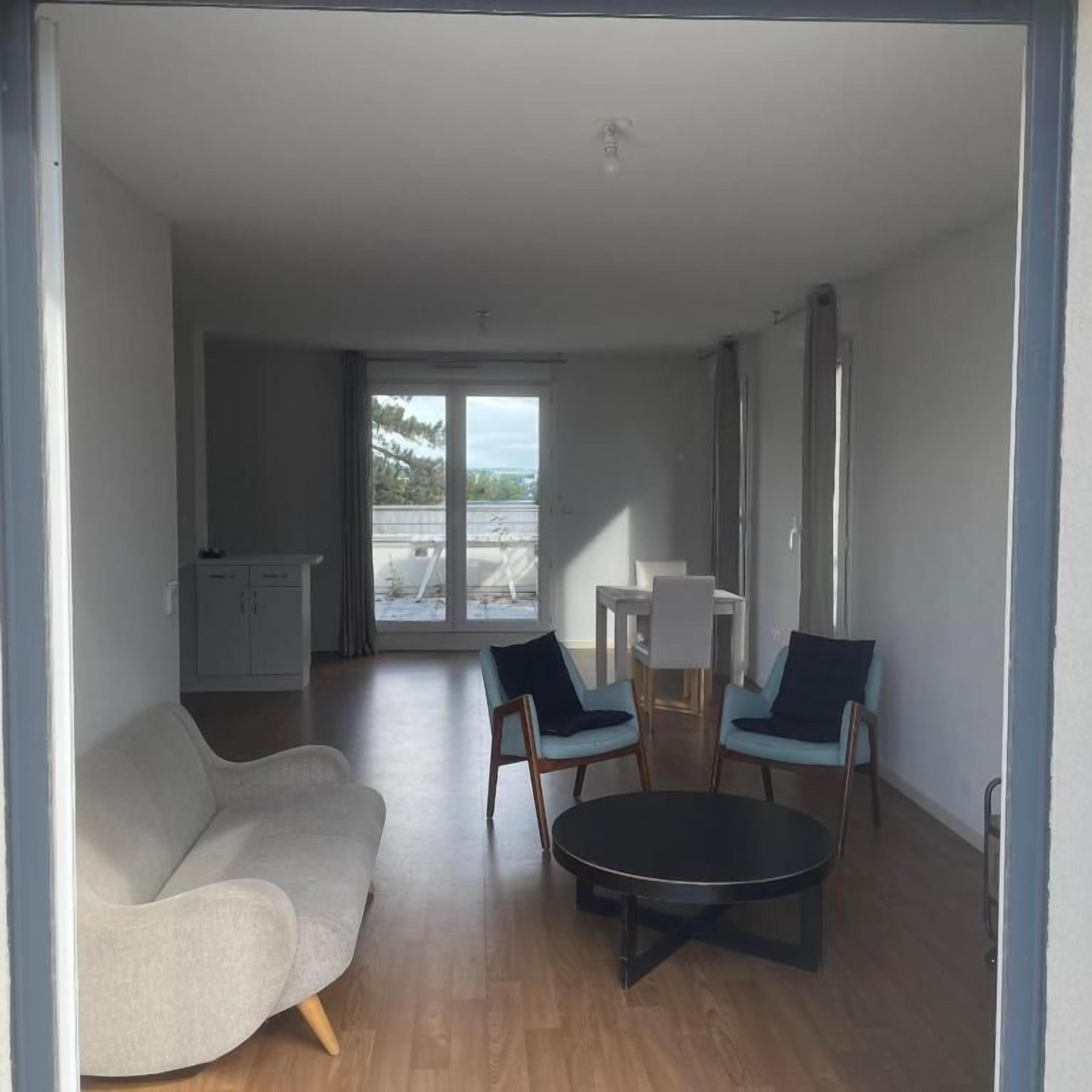 Sala de estar moderna com sofá, duas poltronas, mesa de centro e vista para área externa através de uma porta de vidro.