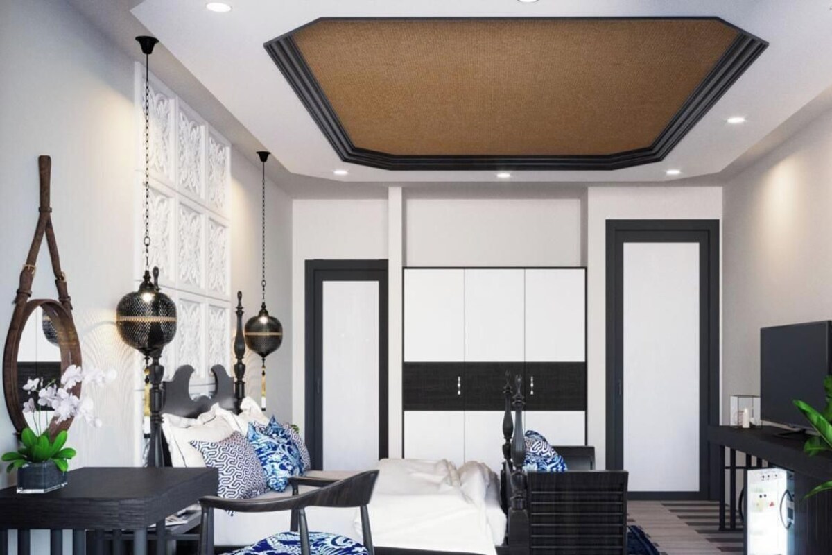 A modern bedroom with a large bed, bedside tables, a desk, and a television.