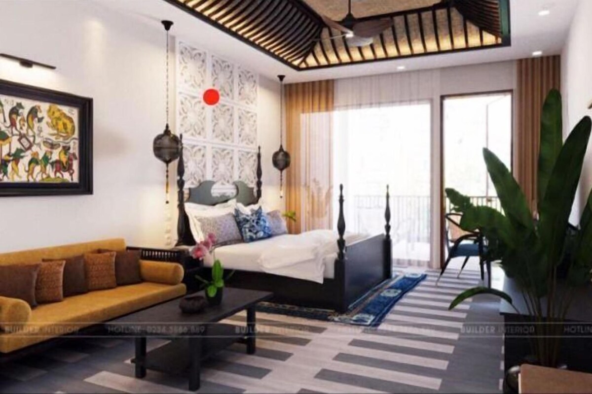 Una habitación de hotel moderna con cama, sofá y una planta grande.