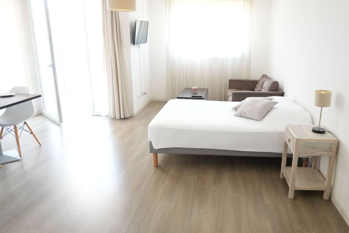 Una habitación de hotel moderna con una cama grande, un escritorio y una silla.