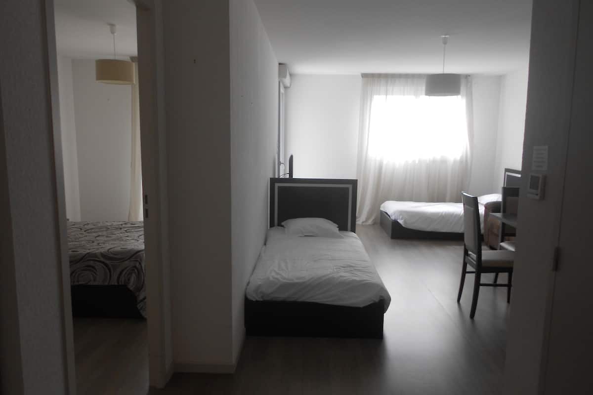 Una habitación de hotel con una cama individual, un escritorio y una silla.
