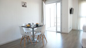 Un comedor moderno con una mesa, sillas y vistas al exterior.
