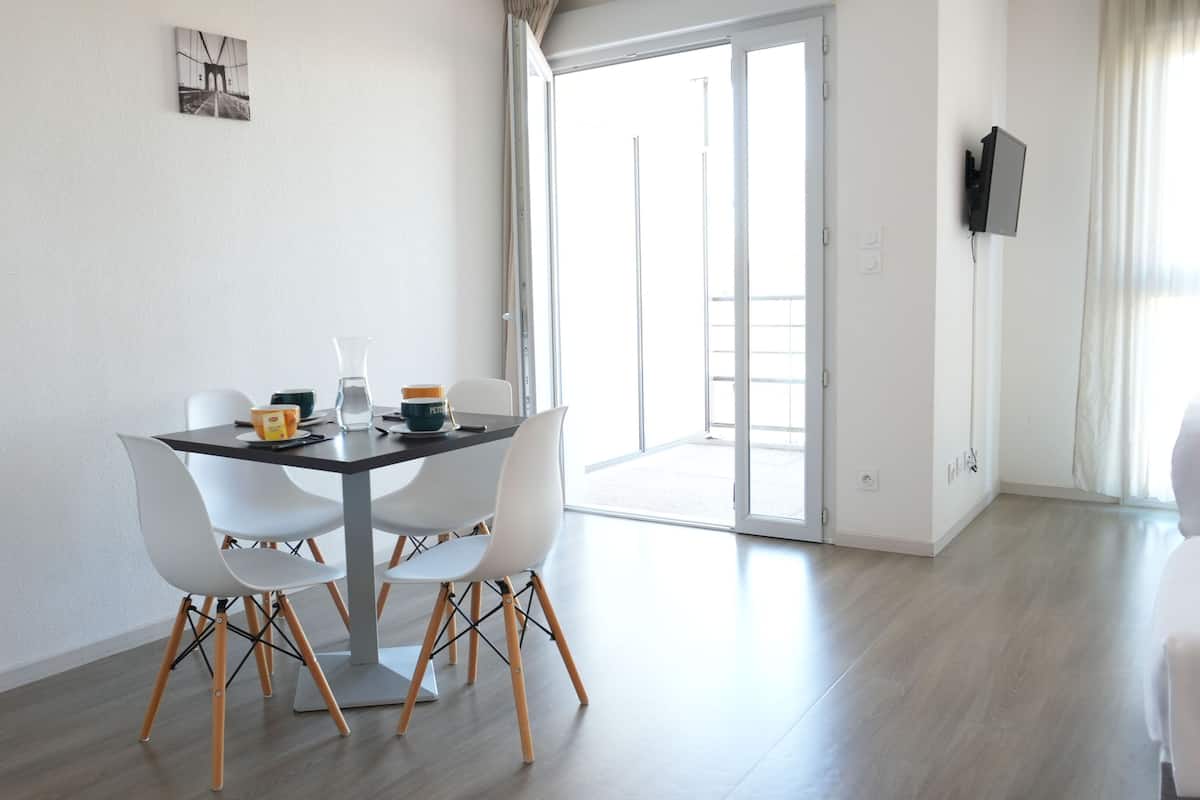 Un comedor moderno con una mesa, sillas y vistas al exterior.
