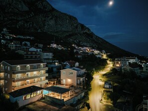 A residential area with houses, a swimming pool, and a road leading uphill.