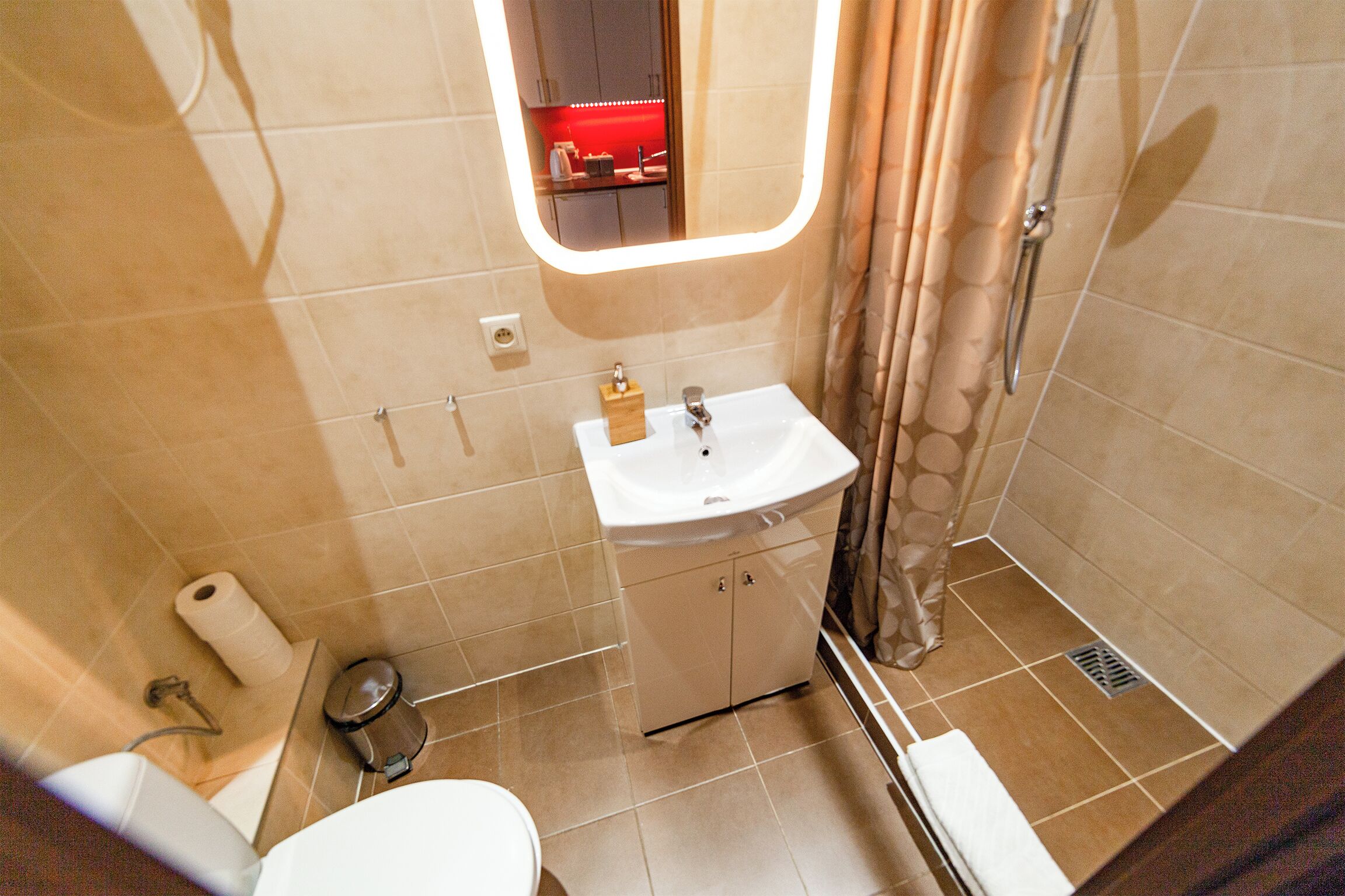 A small bathroom with a toilet, sink, and shower.