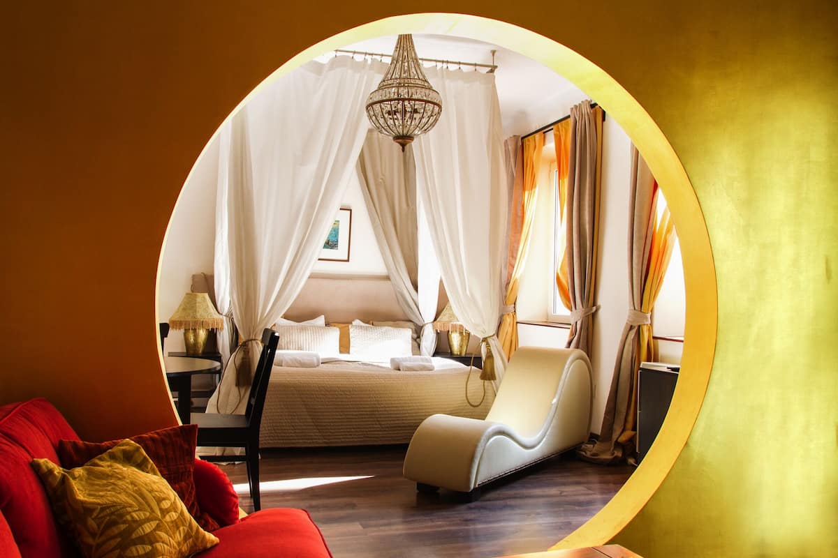 A circular room with a bed, a chair, and a lamp.
