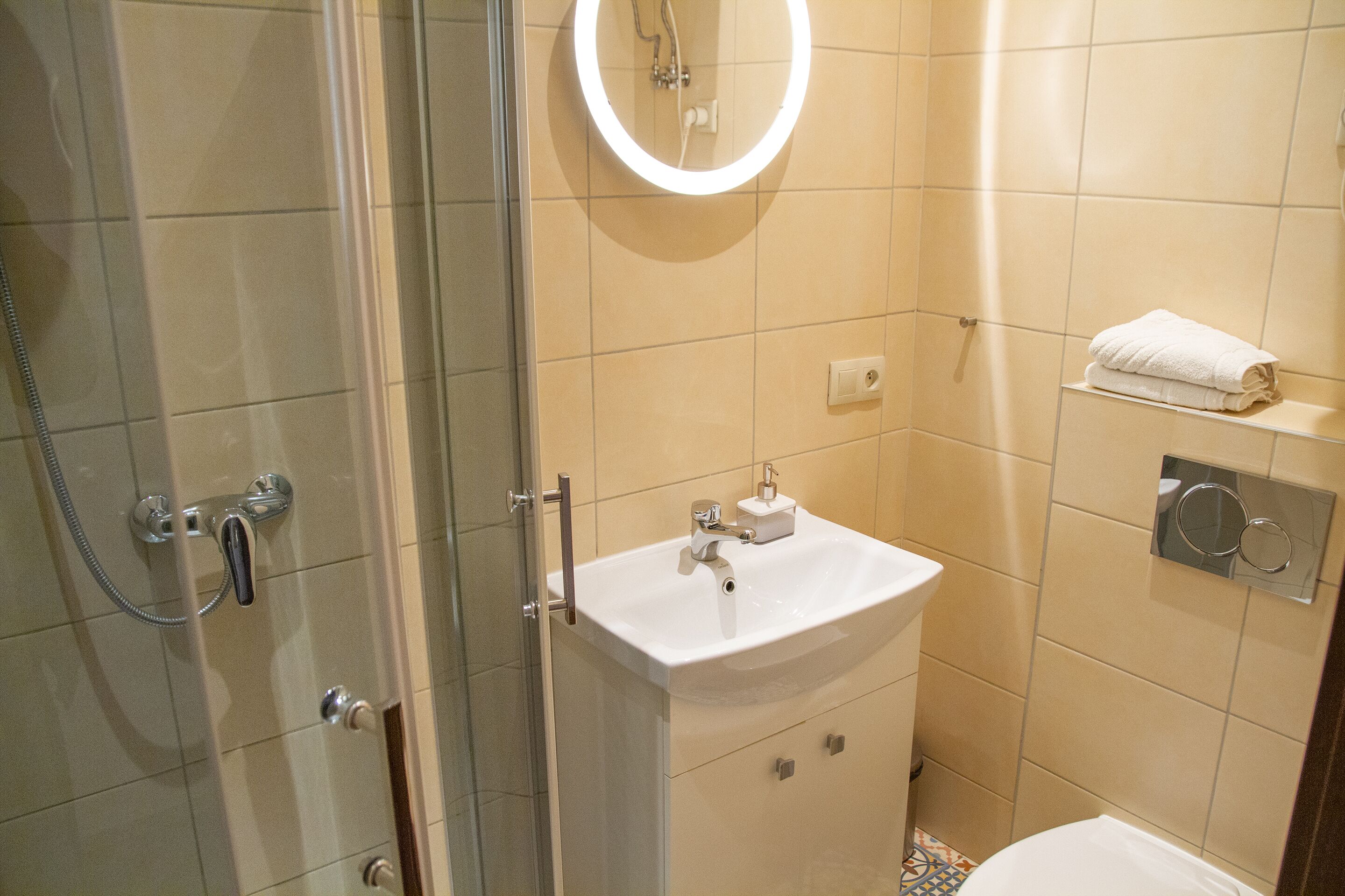 Une salle de bain avec une douche à parois de verre, un lavabo blanc et des toilettes.