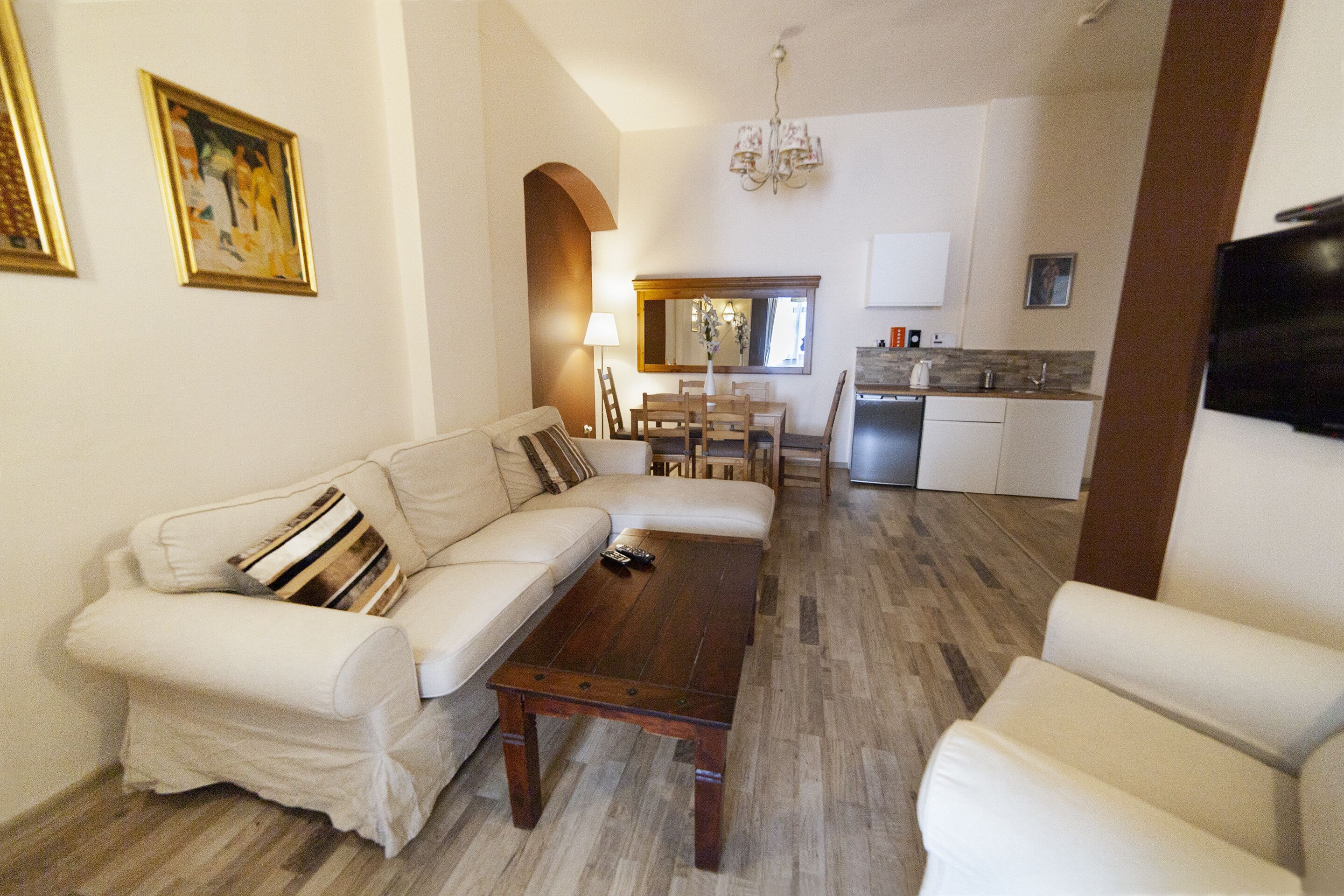 A living room with a sofa, armchairs, a coffee table, and a dining area with a table and chairs.