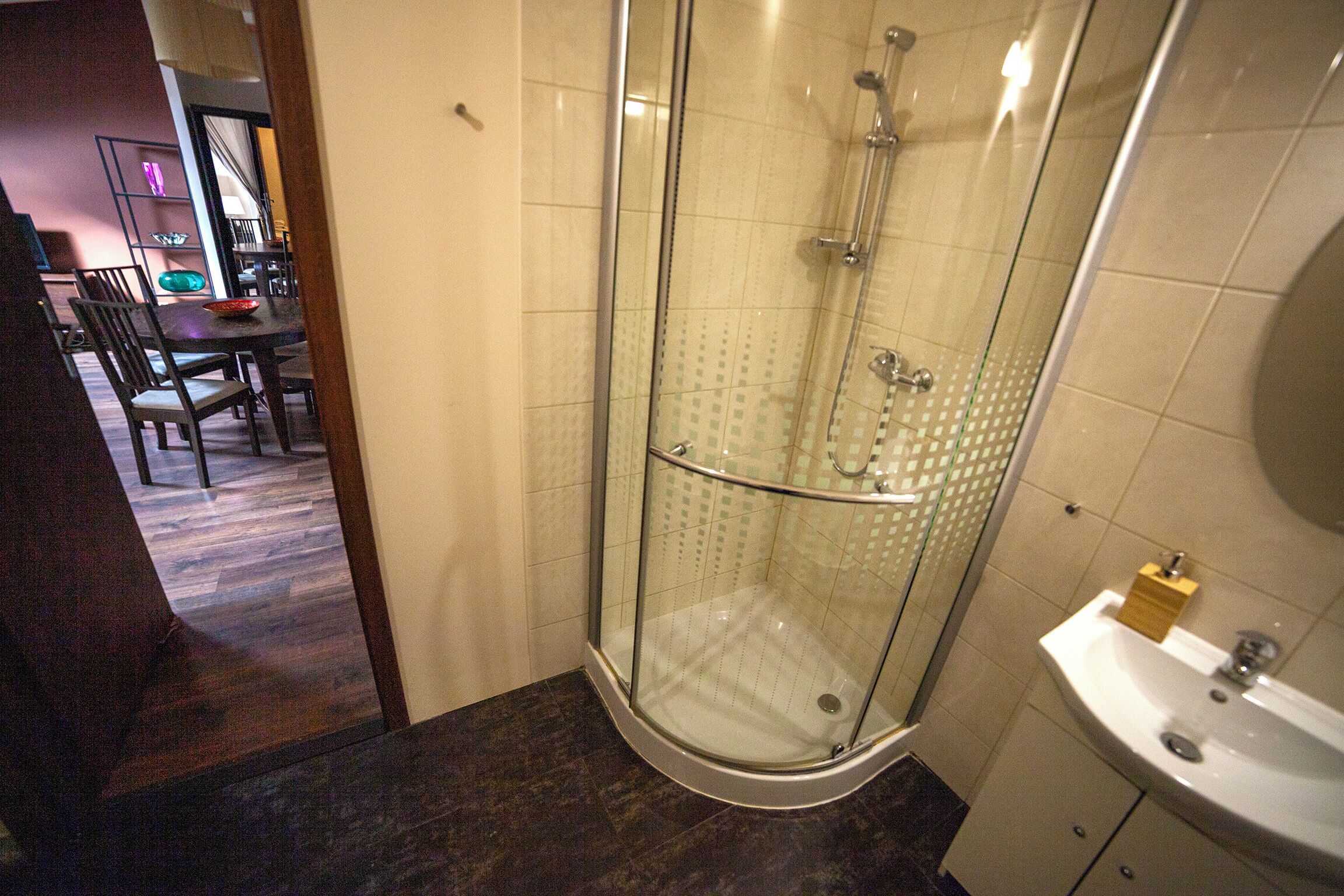 A glass-enclosed shower with a sink and a mirror.