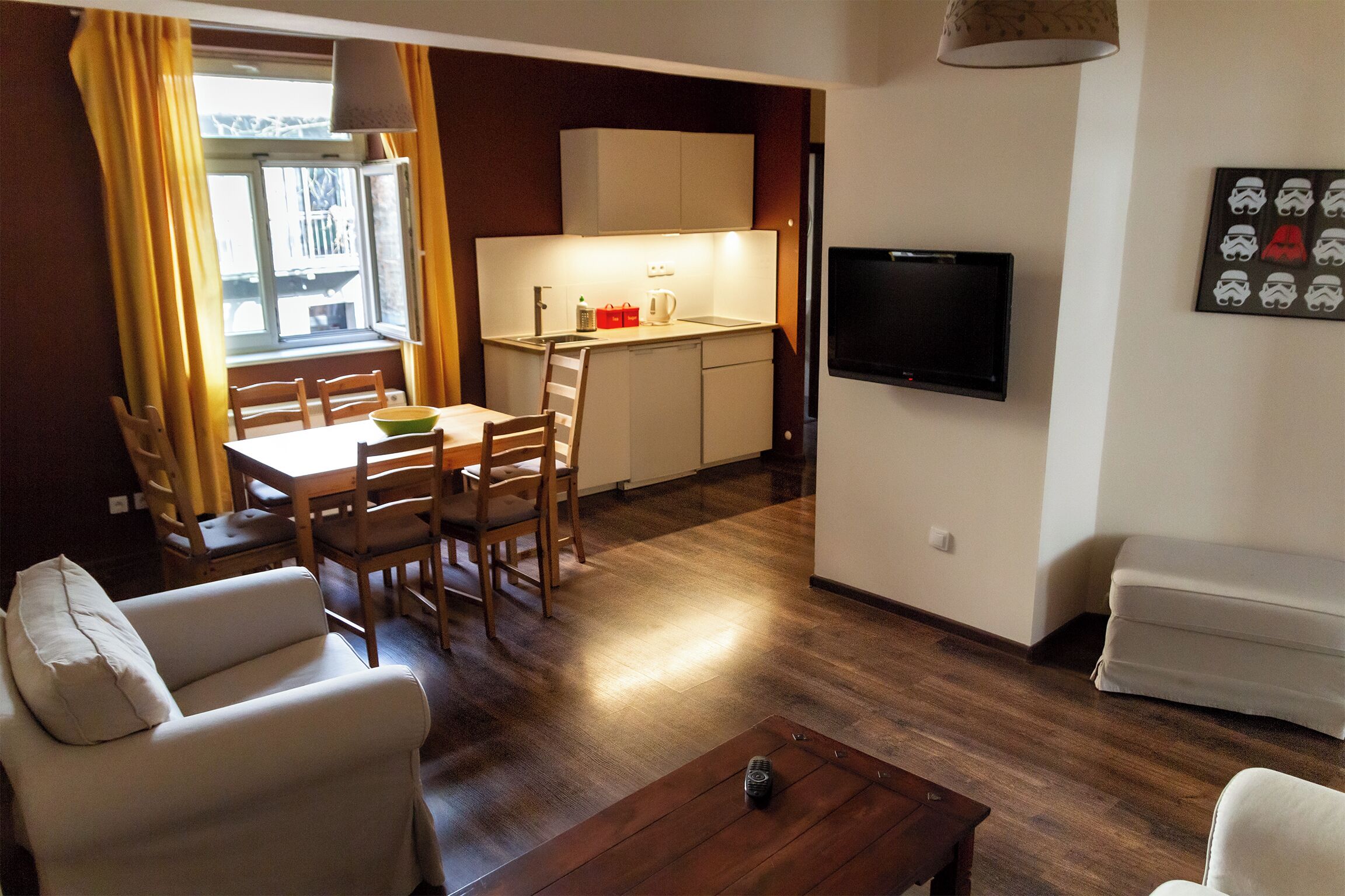 Un espacio habitable compacto con comedor, kitchenette y zona de estar.
