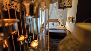 A bedroom with a bed, curtains, and wall-mounted lights. - Lounge Apartments (Kraków)