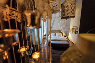 A bedroom with a bed, curtains, and wall-mounted lights.