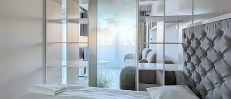 A modern bedroom with a large bed, built-in shelving, and a view of the outdoors.