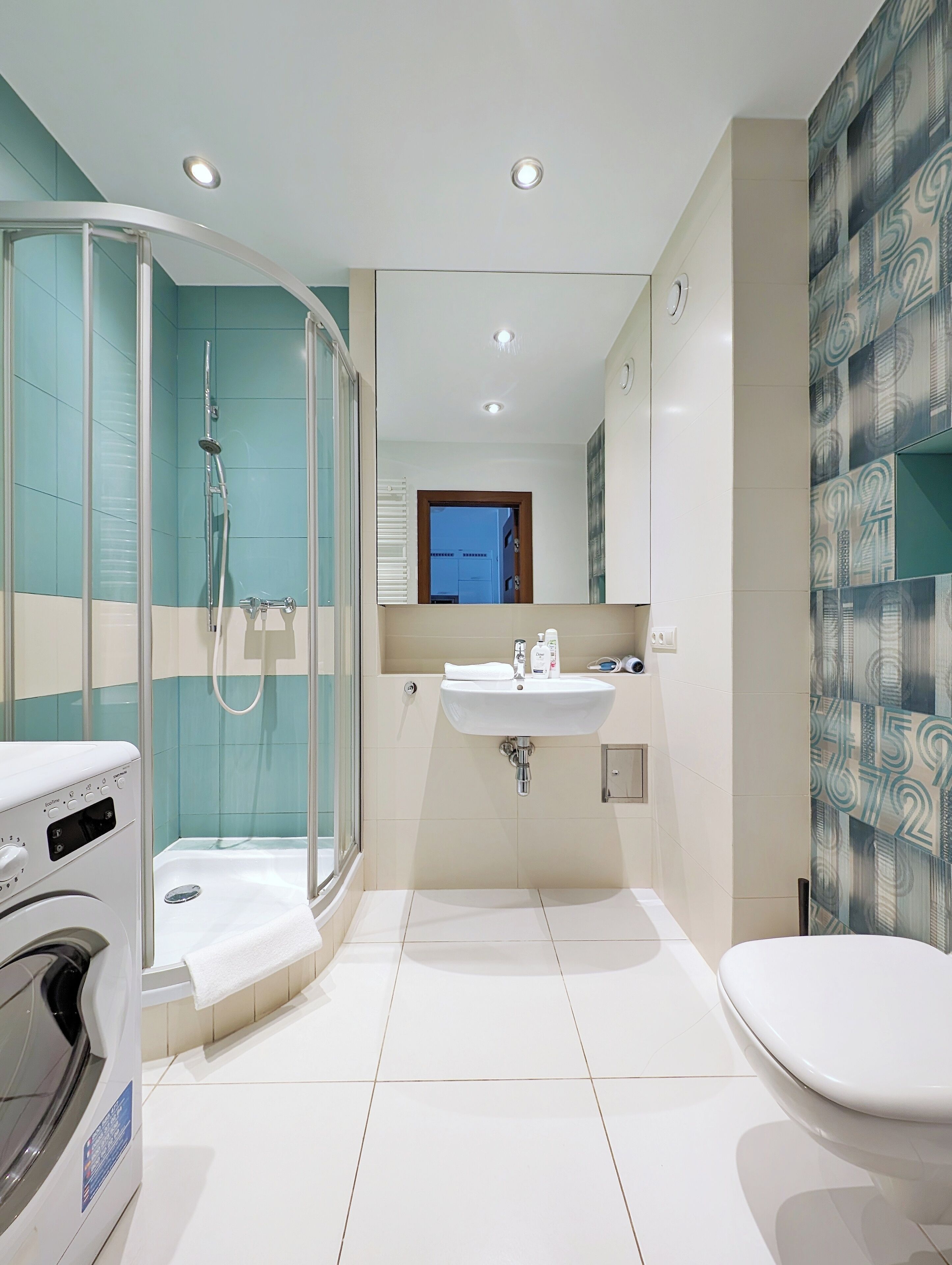 A modern bathroom with a glass-enclosed shower, a sink, and a toilet.