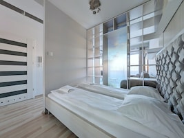 Une chambre moderne avec un grand lit, un placard intégré et une vue sur l’extérieur.