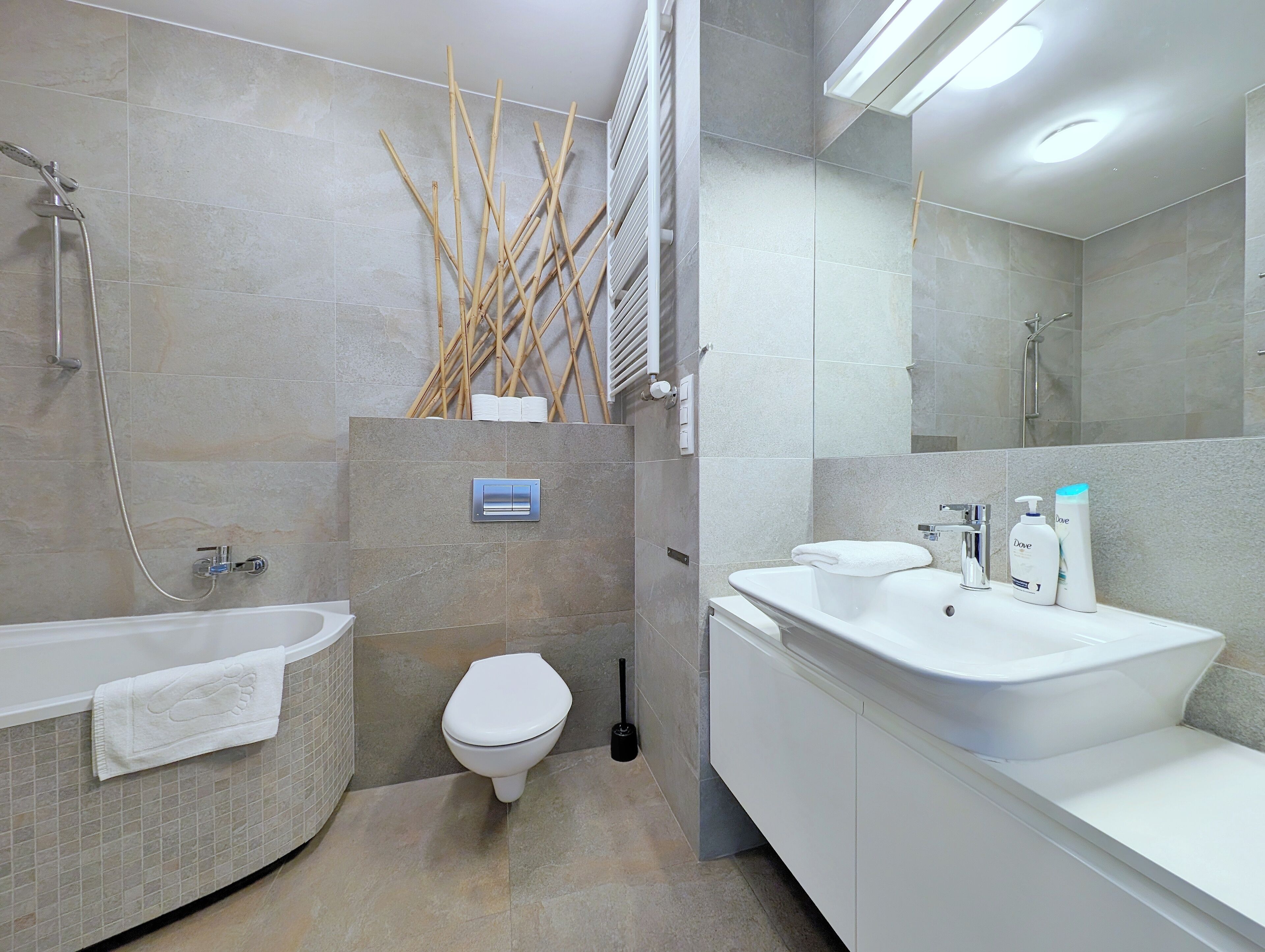 A modern bathroom with a bathtub, toilet, and sink.