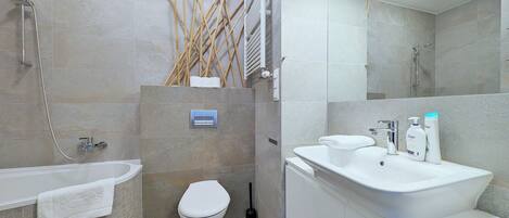 A modern bathroom with a bathtub, toilet, and sink.