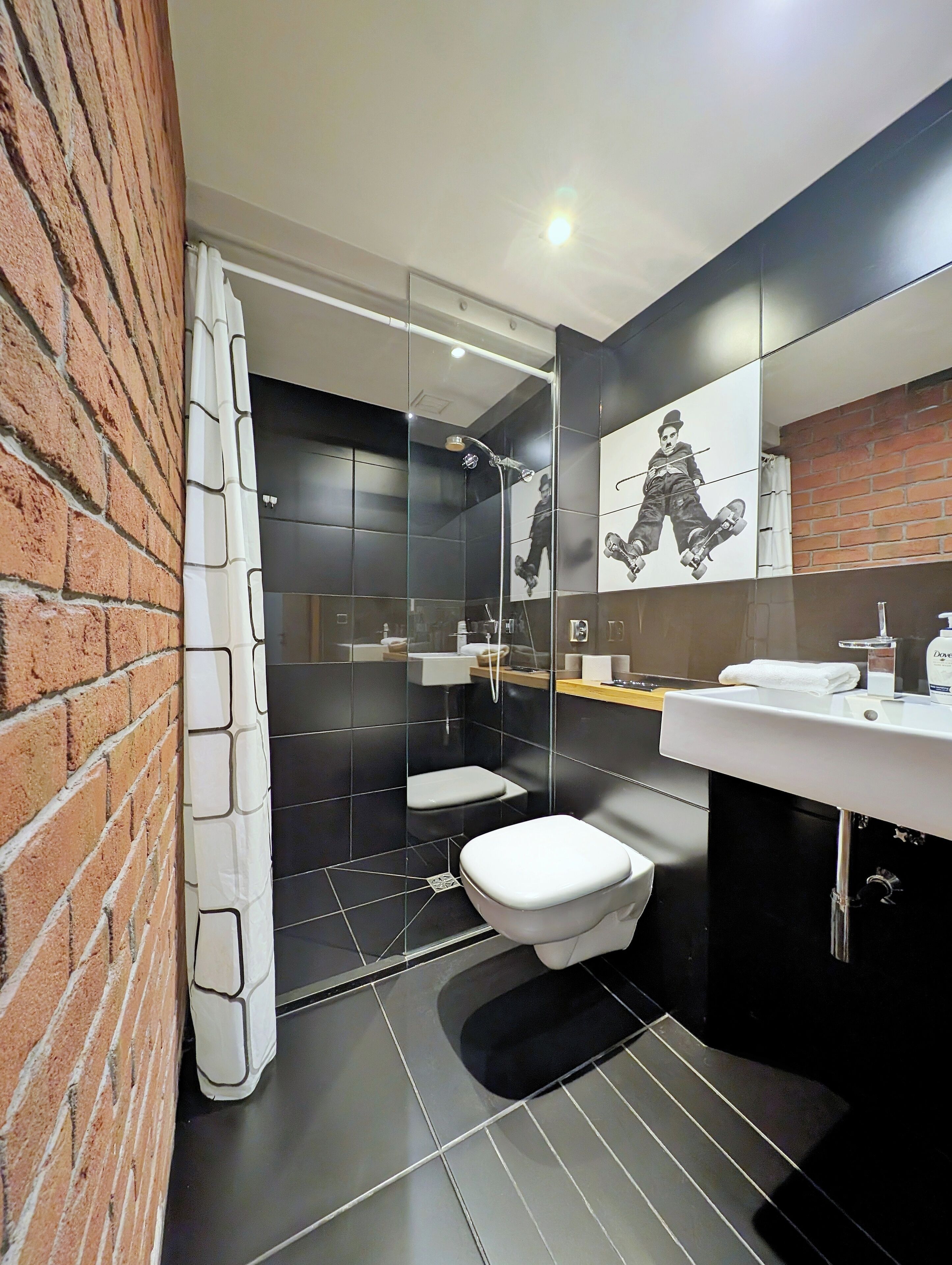 Un baño moderno con ducha, inodoro y lavamanos.
