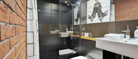 Un baño moderno con ducha, inodoro y lavamanos.