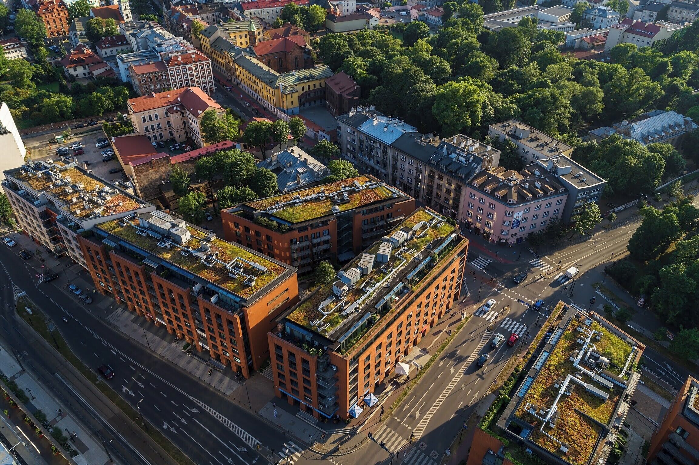 An aerial view of a cityscape with buildings, roads, and greenery.
