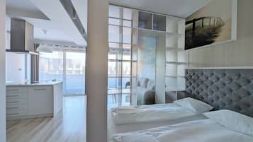 Una moderna camera d'albergo con un letto grande, un'area pranzo e vista sulla città.