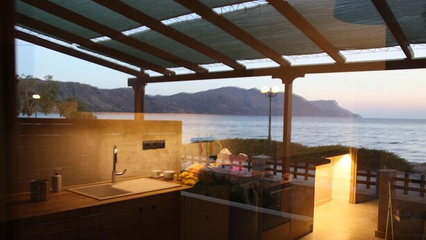 Cozinha externa com vista para o mar e montanhas.
