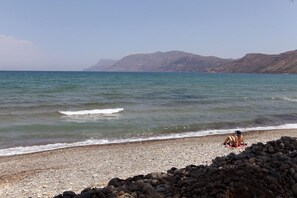 Rannalla, aurinkotuoleja, aurinkovarjoja