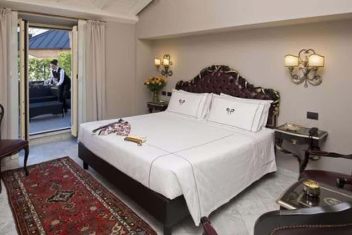 Une chambre à coucher avec un grand lit, un tapis rouge à motifs, un bureau avec une chaise et une table de chevet avec une lampe.