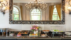 Montaje de bufé con diversos alimentos y un espejo decorativo arriba.