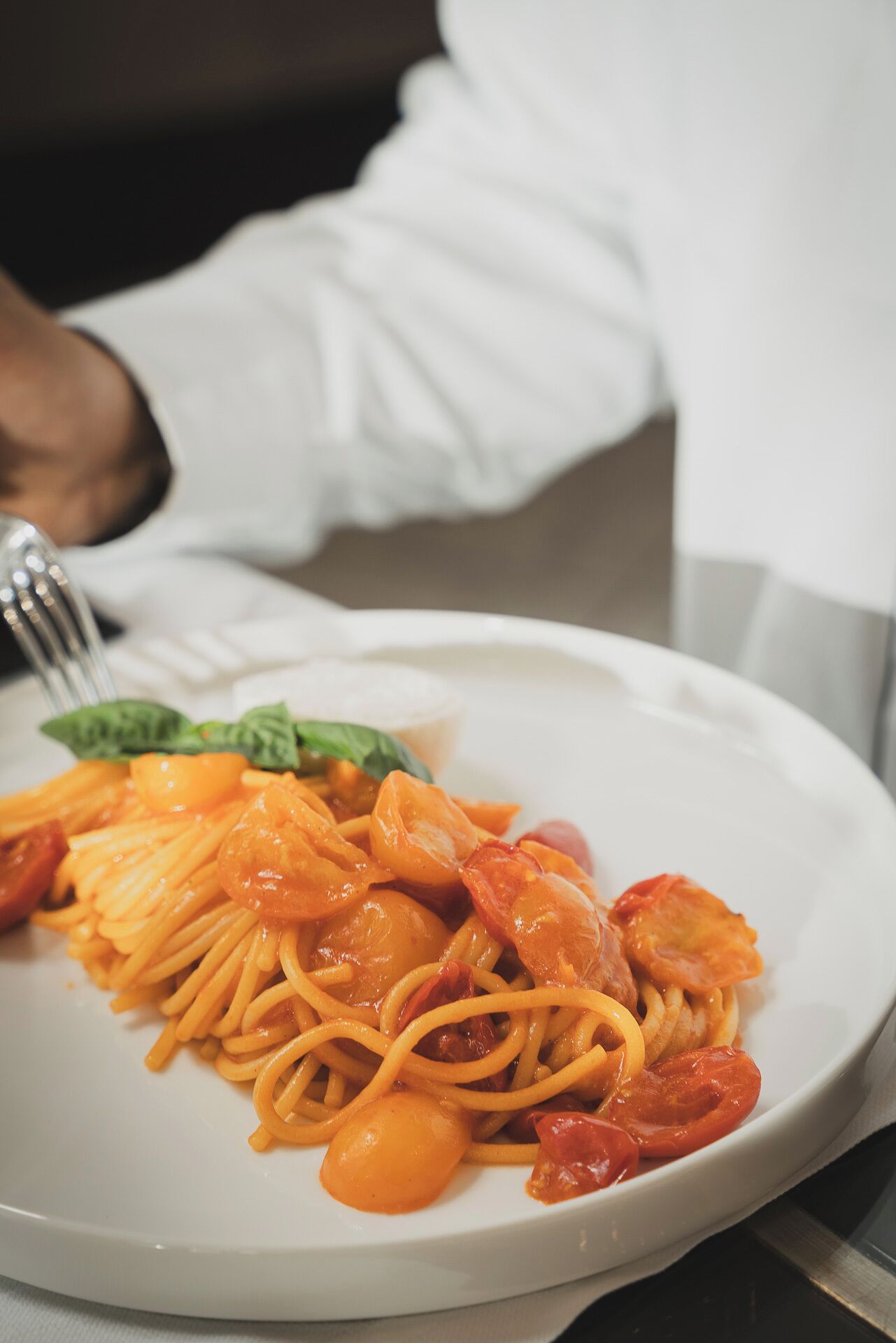 Un piatto di spaghetti con pomodorini e gamberi.