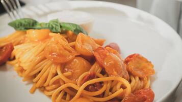 Un piatto di spaghetti con pomodorini e gamberi.