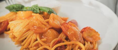 A plate of spaghetti with cherry tomatoes and shrimp.