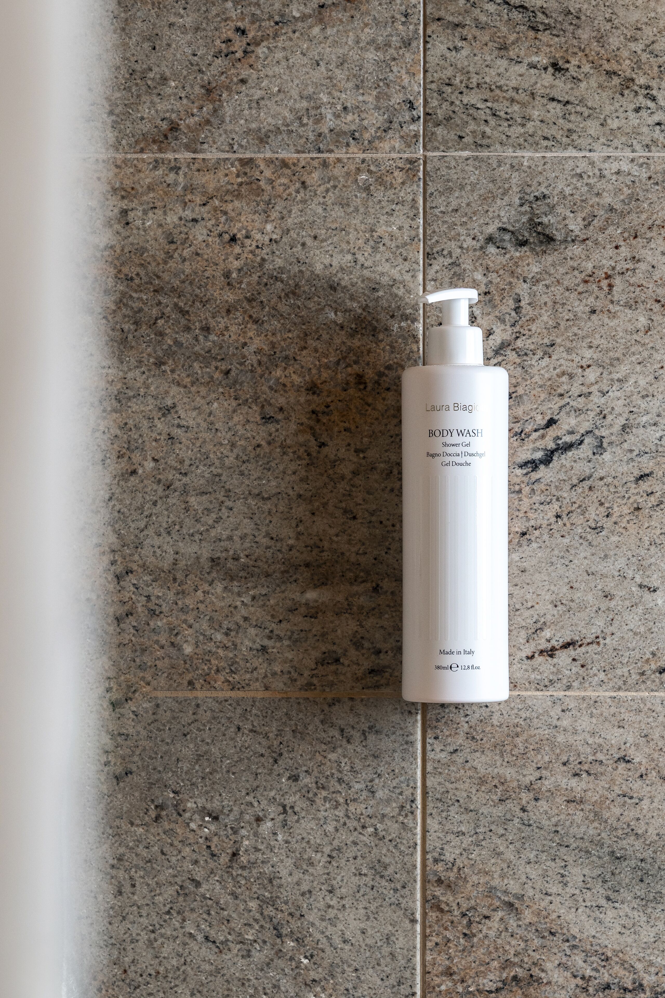 A bottle of Laura Biag Body Wash on a granite countertop.