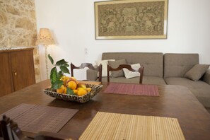 Ein Esstisch mit Obstkorb, Platzsets und einer Lampe.