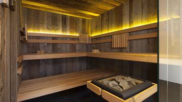 A sauna with wooden benches and a central heated stone feature.