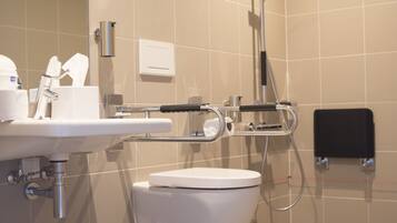Un baño moderno con lavamanos, inodoro y ducha.